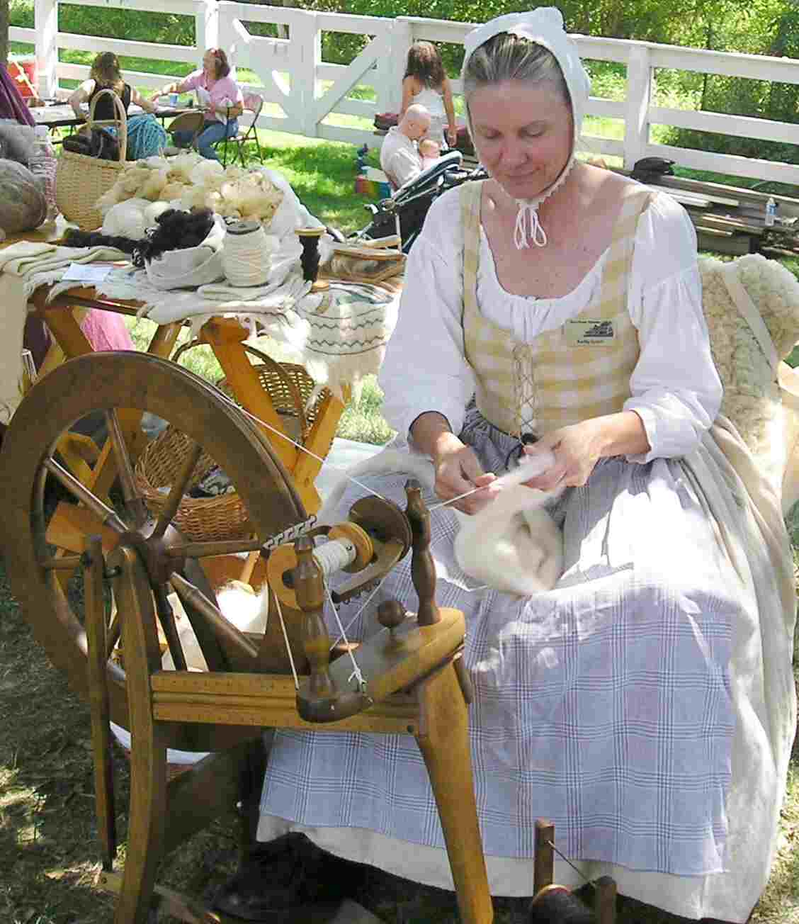 Kathy Scholl  show visitors how
 18th century housewives carded and spun wool
  into yarn and flax into thread.